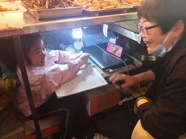 The little girl studying under the chopping board,